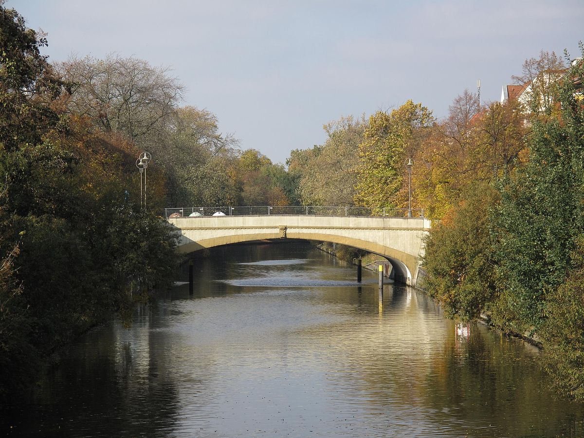 Wildenbruchbrücke mit Wasser und grüner Uferböschung in mildem Sonnenlicht